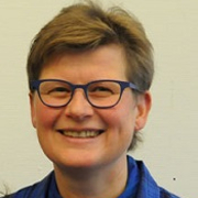 Lachende Frau mit kurzen braunen Haaren und Brille